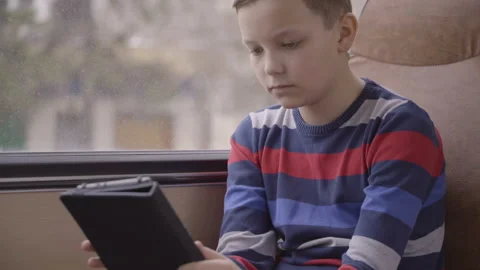 Close-up shot of a young boy traveling by bus through city, using social network Stock Footage 90362653
