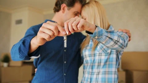 Close up shot of young couple hands holding key from their new stylish home on Stock Footage