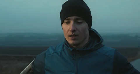 Close up shot of young determined man runner standing outdoors exhausted after Stock-Footage 148330350