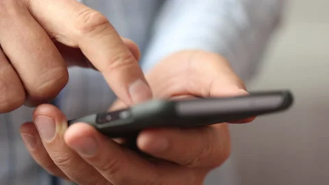 Close up shot of a young male scrolling and typing on his phone Stock Footage 162373953