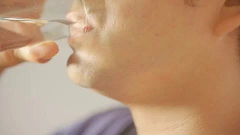 Close up shot of young man drinking mineral water from a glass Видео 320198399