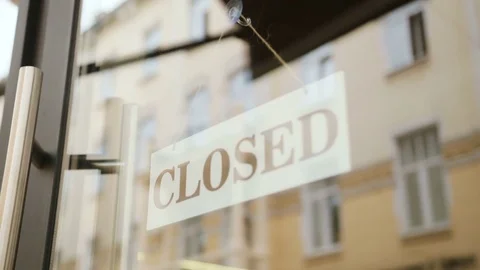 Close up shot of young man hands turning over a "close" sign on the door of cafe Stock Footage 78653559