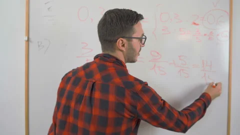 Close shot of young man math teacher with red shirt and glasses writing complex Stock Footage 139758278