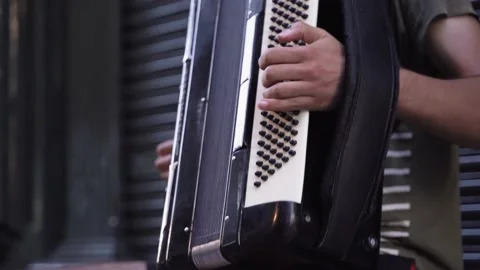 Close up shot of a young man playing accordion on a tourist street in portuga Stock Footage 205966187