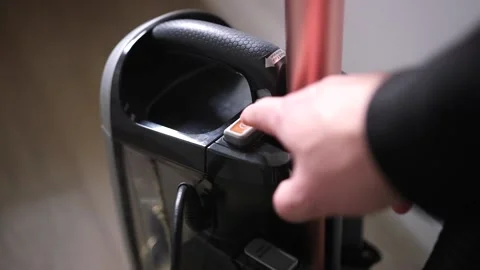 Close Up Shot of Young Man Pressing the Power Button On Vacuum Cleaner Stock Footage 147624960