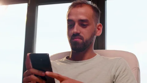 Close up shot of young man smiling while looking at the smartphone screen Stock Footage 114311115