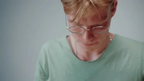 Close-up shot of young man studying and stressing, reading in empty grey room Stock Footage 164374737