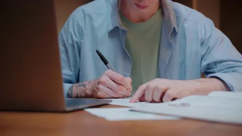 Close-up shot of young man studying, writing notes and looking at the laptop Stock Footage 164374963