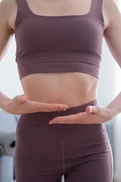 Close up shot of a young woman doing yoga exercises in the living room at home Stock Photos