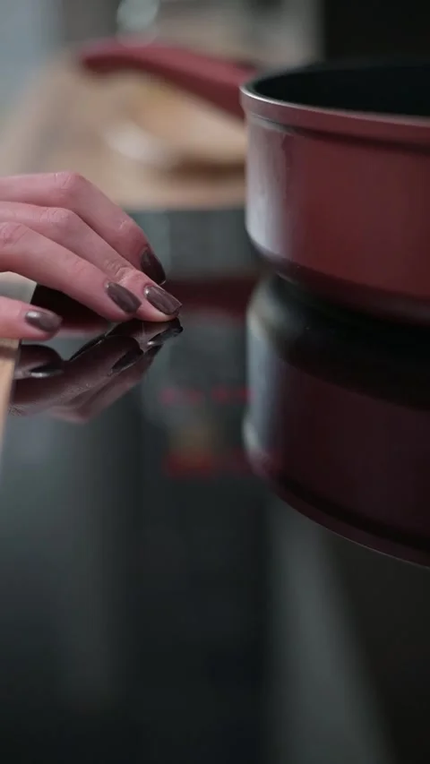 Close-up shots of hands preparing food beside a cooking pot on a smooth kitchen 스톡 동영상 337112322