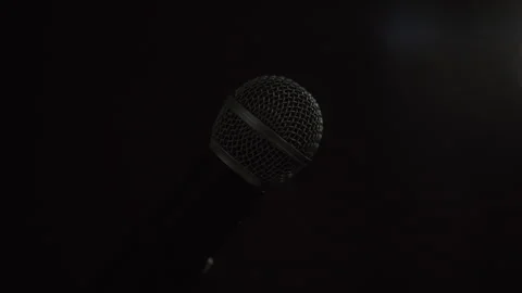 Close up shots microphone on stage with spotlight strike through the darkness. Video stock 241092090
