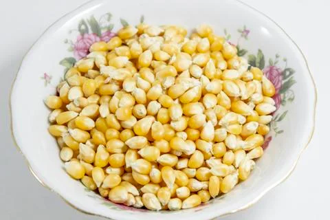Close-up shots of multiple corn seeds in the small white cup Stock Photos