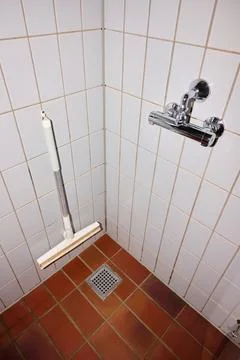 Close up of a shower drain and squeegee. Stock Photos