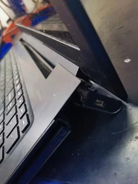 A close-up showing a detached screen bezel and a broken hinge on a black laptop Stock Photos