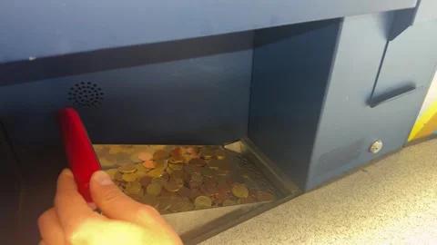 A close-up shows a coin counting machine, coins are loaded into the device Stock Footage 330607761