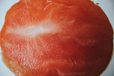 A close-up shows the cross-section of a sliced, ripe red tomato. Stock Photos