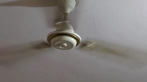 A close-up shows a fan's pull chain swaying violently at high speed, representin Stock-Footage 343784848
