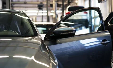 Close-up shows the front of a car with an open door which is in a car service. Stock-Fotos