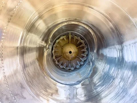 A close-up shows the inside of a jet engine at an aircraft maintenance facili Stock Photos