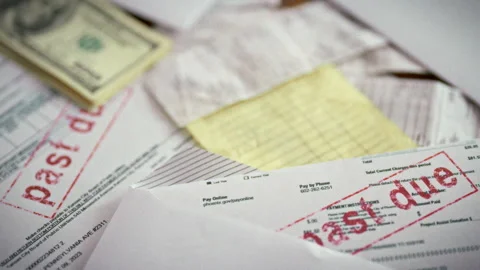 A close-up shows a red late payment stamp on a pile of overdue bills and a f Stock Footage 336570081