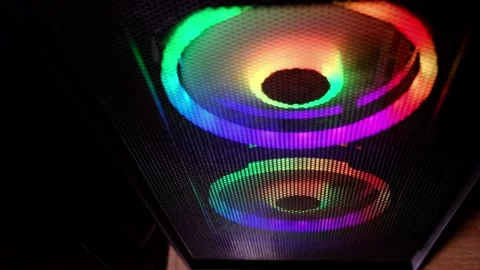 Close up shows RGB ring lights glowing inside a gaming PC case, colorful fans Stock Footage 329924515