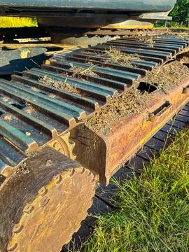The close-up shows a rusty track from construction machinery resting on a woo Stock Photos