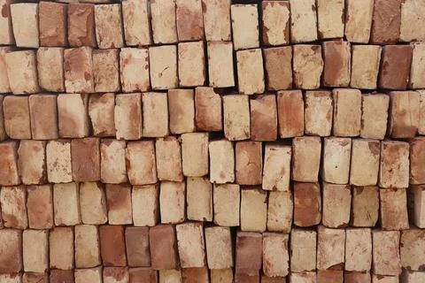 Close up shows stacked bricks with variations of beige and earthy red tones.  写真素材