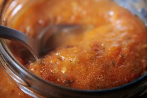 A close-up shows thick, orange-red tomato sauce. Stock Photos
