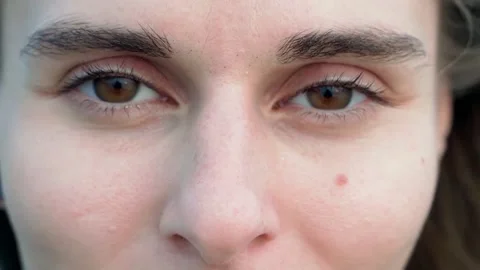 Close up shows a woman's face looking directly at the camera. Video stock 234020625