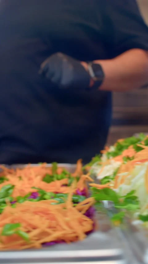Close-up of shredded carrots and chopped herbs on stainless kitchen prep surface Видео 336534533
