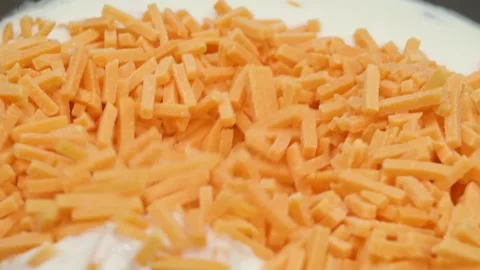 Close-up of Shredded Carrots Being Mixed with a Creamy White Sauce in a Bowl Stock Footage 331633586