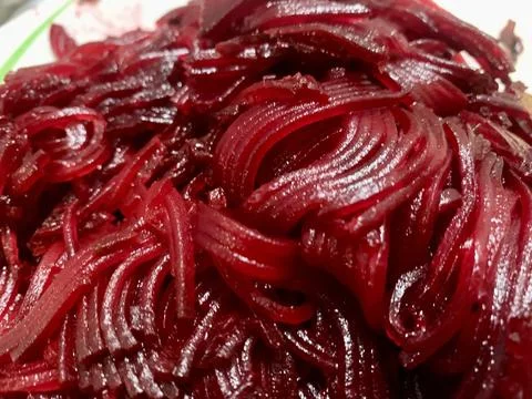 A close-up of shredded red beets showcasing their glossy texture and vivid Foto stock