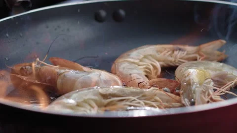 Close-up of shrimp being cooked in a frying pan with a blazing fire Stock Footage 158815562