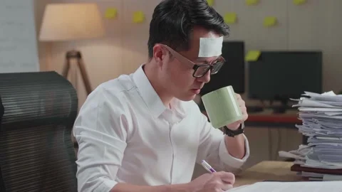 Close Up Of Sick Asian Man Drinking Water While Working Hard With Documents Stock Footage 196120483