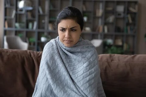 Close up sick Indian woman covered with blanket feeling unhealthy Stock Photos