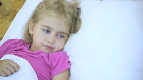 A close-up Sick little girl having her temperature. Child with a fever: She Stock Footage