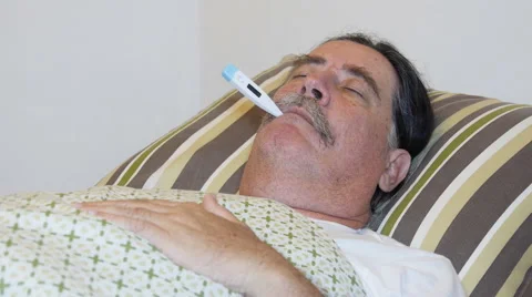 Close-up of sick man in bed with fever and thermometer. Stock Footage 61304501