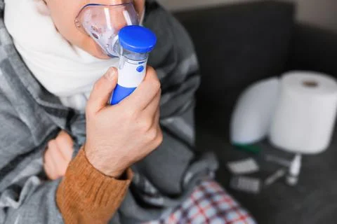 Close up of sick man using nebulizer mask for respiratory inhalation treatm.. Stock Photos