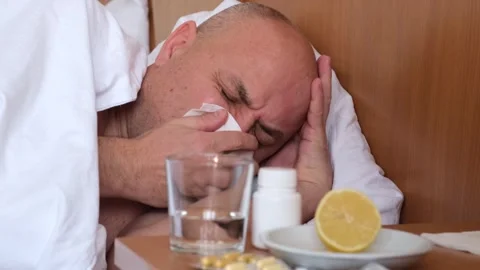 Close up sick middle age man lying on bed at home, sneezing and blowing nose Stock Footage 301894259