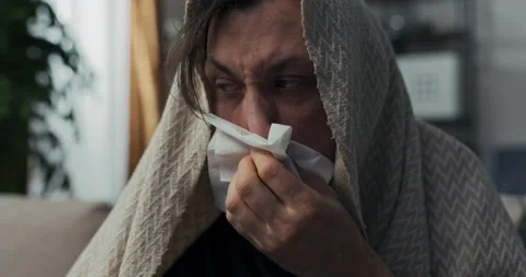 Close-up of sick young man with beard. Brunette blows snot into napkin, because 스톡 동영상 218331486
