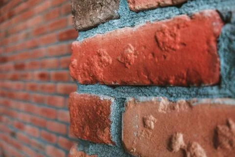 Close up side angle view of cracked weathered red brick wall corner. Stock Photos