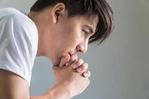 Close up the side of handsome man sitting with his hands under his chin thoug Foto stock