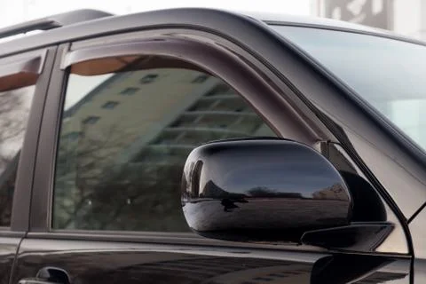 Close-up of the side left mirror and window of the car body black SUV on the  Stock Photos