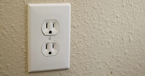 Close Up Side of Man's Hand Plugging Cord Into Electrical Outlet Then Stock Footage 105998794