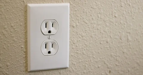 Close Up Side of Man's Hand Plugging Cord Into Electrical Outlet Then Stock Footage 105999390