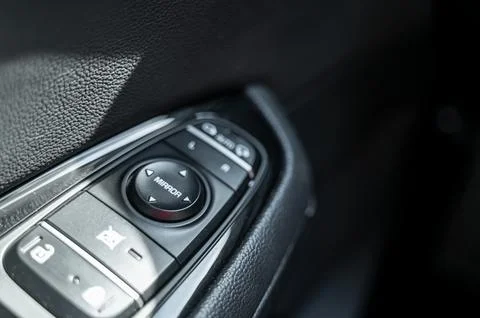 Close-up of side mirror adjustment button on the car door panel Stock Photos