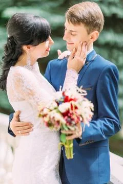 The close-up side portrait of the bride stroking the cheek of the groom. Stock Photos
