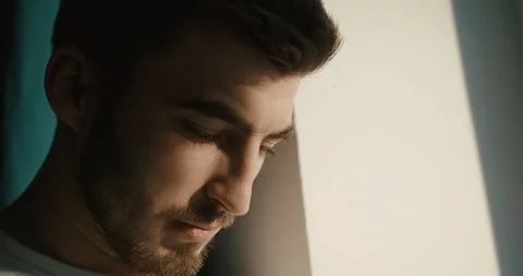 Close-up side portrait of the serious handsome guy raising his eye up and Video stock 93351639