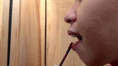 Close Up Side Profile of Woman Applying Liquid Lipstick Stock Footage 338084586
