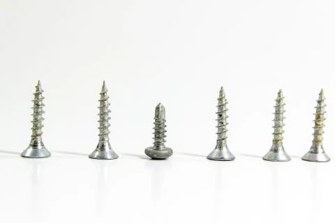 Close side shoot of multiple screws on white blurry background Stock Photos